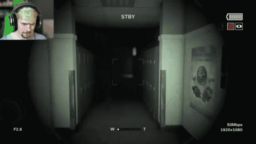 a man wearing headphones is playing a video game with stby on the screen