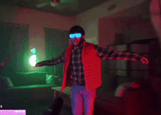 a man in a red vest is dancing in a room with a sign that says s