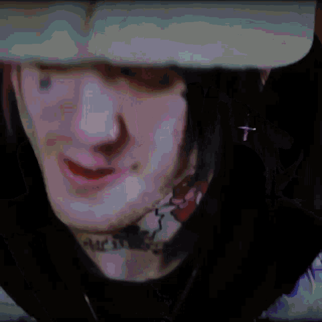 a close up of a person 's face with tattoos and a helmet on