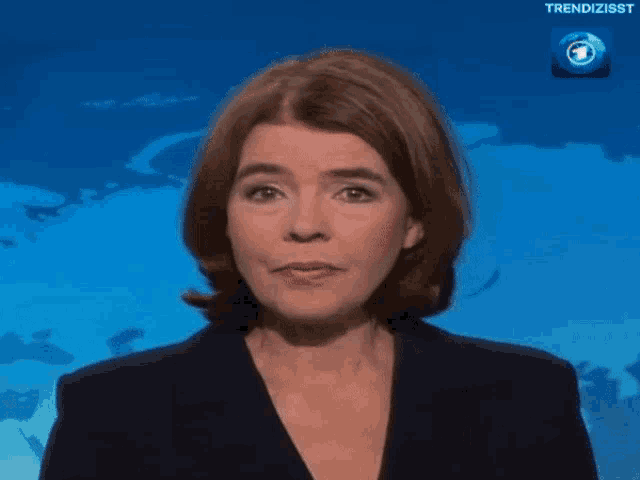 a woman with her eyes closed says " gering " in front of a map of the world