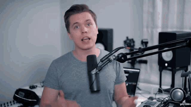 a man speaking into a microphone with the website gifs.com visible in the background