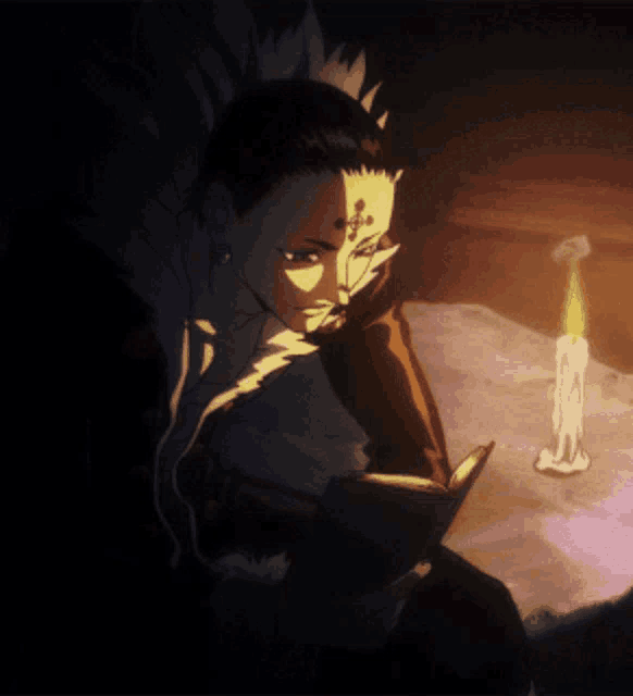 a man is reading a book next to a candle