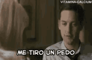 a man is sitting on a couch talking to a woman and says me tiro un pedo