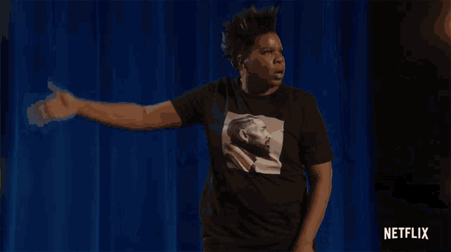a person wearing a black t-shirt with a picture of a man 's face on it