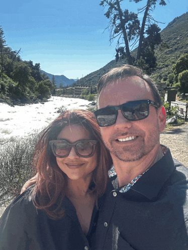 a man and woman wearing sunglasses pose for a picture