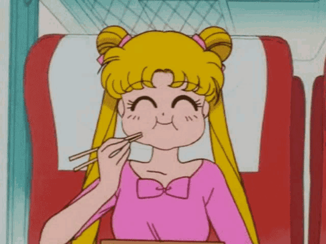 a girl in a pink shirt is eating with chopsticks .
