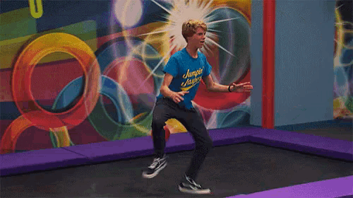 a boy is jumping on a trampoline wearing a blue shirt that says jumping super