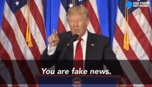 donald trump speaking at a podium with the words you are fake news