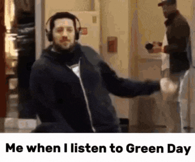 a man wearing headphones is dancing in a room with the caption me when i listen to green day .