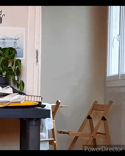 a wooden folding chair sits in front of a window with a power director watermark