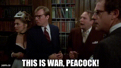 a man and a woman are standing in a room and the woman is saying this is war peacock