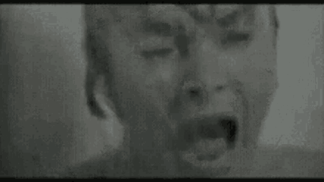 a close up of a woman 's mouth with a needle sticking out of it in a black and white photo .