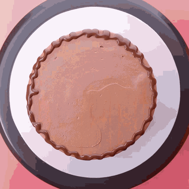 a chocolate cake on a white plate with a black border