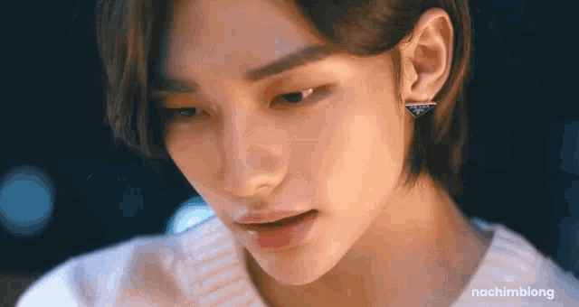 a close up of a person wearing earrings and a sweater .
