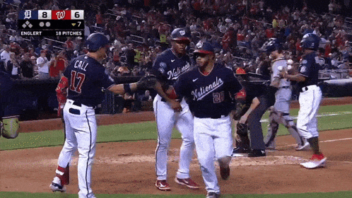 a baseball player wearing a nationals jersey shakes hands with a teammate