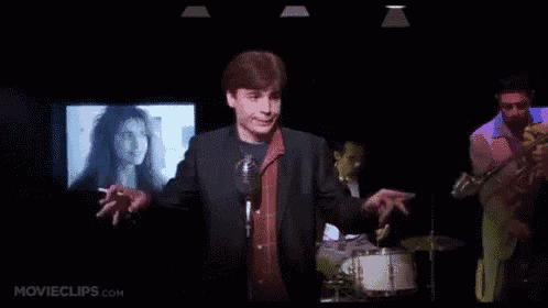 a man singing into a microphone with movieclips.com written on the bottom right