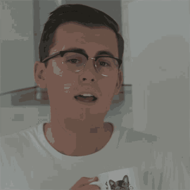 a man with glasses is smiling and holding a cup with the words " you left " below him