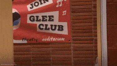 a boy wearing a headband is standing in front of a sign that says glee club