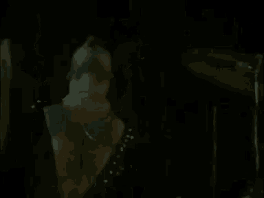 a close up of a person 's face in the dark with a drum set in the background .