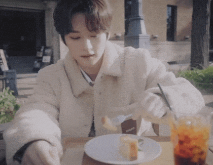 a man is sitting at a table with a plate of food and a drink .