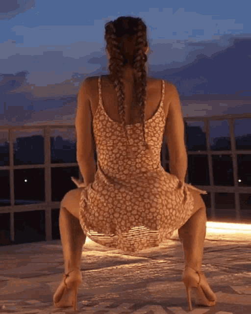 a woman in a dress and high heels is kneeling down