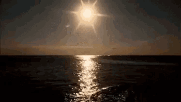 the sun shines brightly over the ocean at sunset