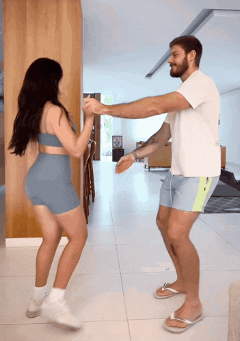 a man and woman are dancing together in a living room