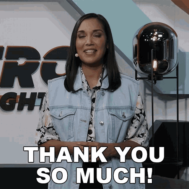 a woman says thank you so much in front of a sign