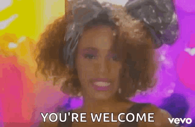 a woman with a bow on her head is smiling and says `` you 're welcome `` .