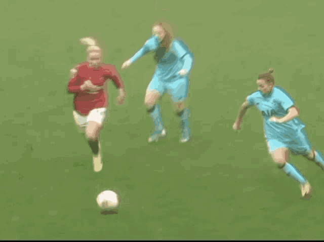 two female soccer players are playing a game of soccer