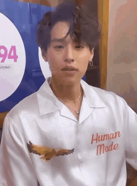 a young man wearing a white shirt with the words human made on it