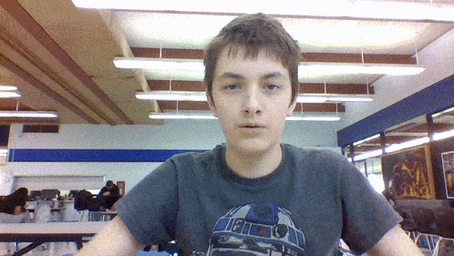 a young man wearing a star wars r2d2 t-shirt