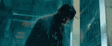 a man is standing in the rain with water coming out of his mouth .