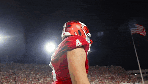 a football player wearing a red jersey with the number 4 on the sleeve