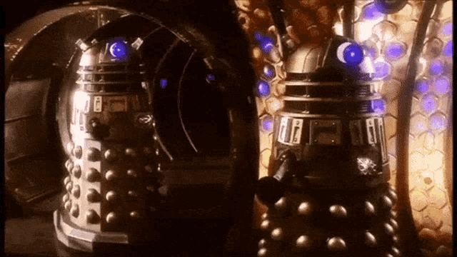 two dalek robots are standing next to each other