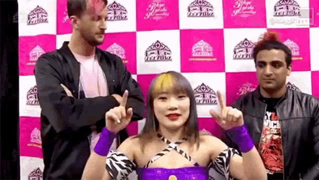 a woman in a zebra print dress is standing in front of a pink and white checkered backdrop .