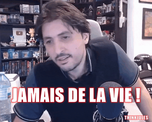 a man sitting at a desk with the words jamais de la vie written in red