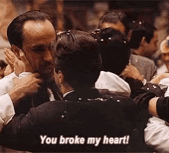 a group of men are hugging each other and one man is saying you broke my heart .
