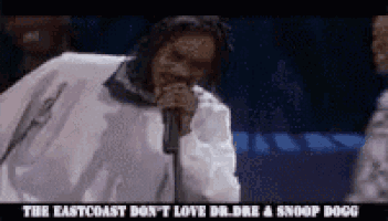 a man singing into a microphone with the words the eastcoast don 't love dr dre and snoop dogg