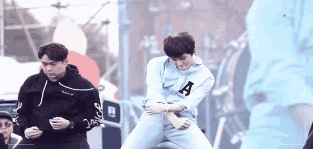 a man in a blue shirt with the letter a on it is dancing
