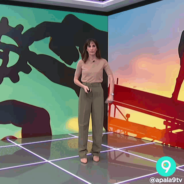 a woman is standing in front of a colorful wall with the number 9 on it