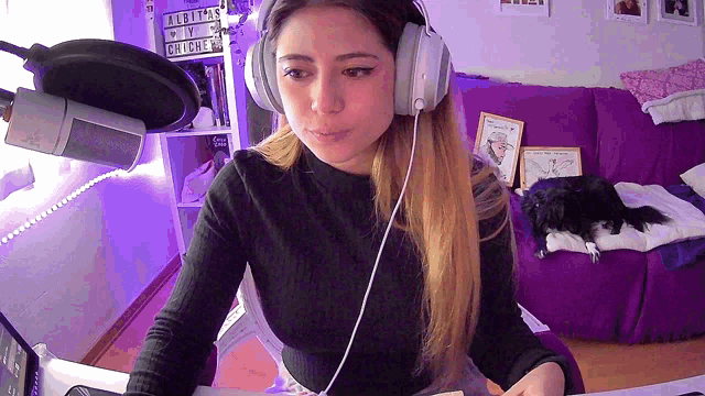 a woman wearing headphones sits at a desk in front of a sign that says albums will be released