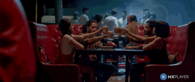 a group of people are sitting at a table with a mxplayer logo on the bottom
