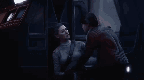 a man and a woman are talking to each other in a dark room .