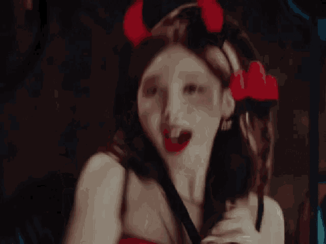 a woman in a devil costume is making a funny face with her mouth open .