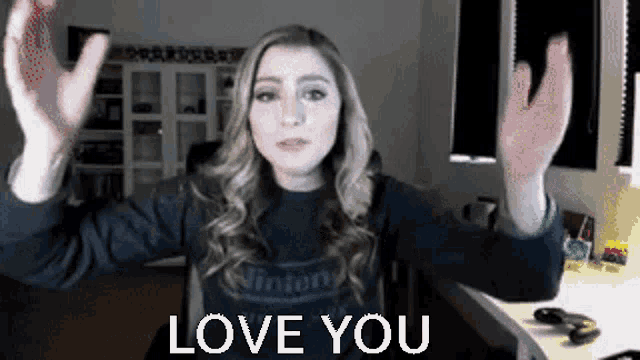 a woman in a nintendo shirt is giving a thumbs up and saying love you