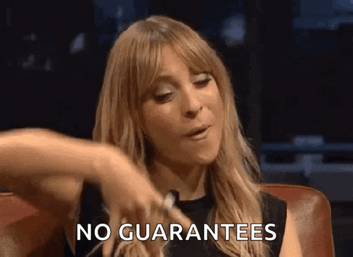 a woman is sitting in a chair and pointing at herself with the words `` no guarantees '' written on her face .