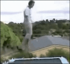 a man is jumping off a trampoline into the air .