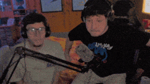 a man wearing headphones and a shirt that says bunny is standing next to another man