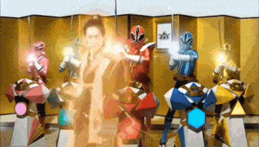 a group of power rangers are standing in front of a gold curtain